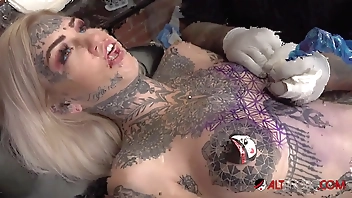 Sascha plays with Amber Luke while she gets tattooed