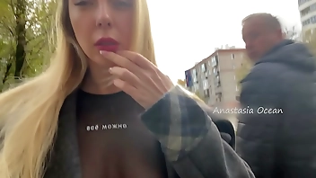 A girl shows her breasts while walking in public in the city